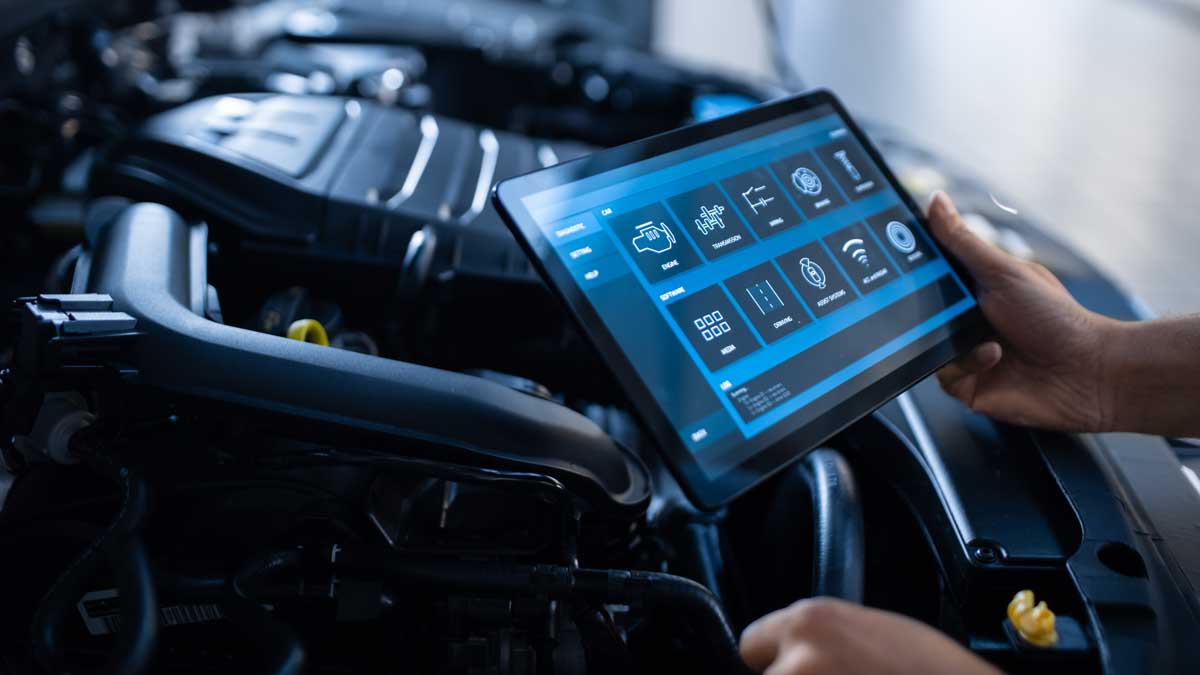 A car mechanic is doing a diagnosis of a car using a smartphone-based app.